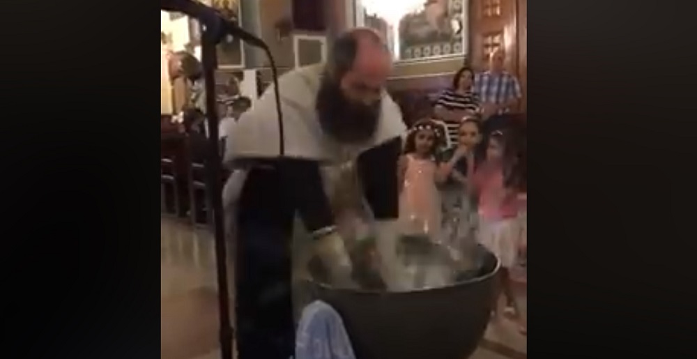 Il video sul prete che battezza un bimbo, è polemica in tutto il mondo
