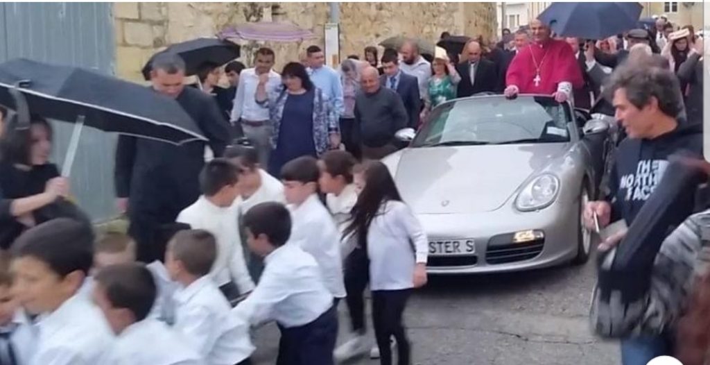 Arcivescovo in processione su una Porsche trainata da 50 Bambini